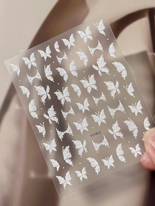 Detail of white 3D embossed butterfly nail art stickers with textured relief designs