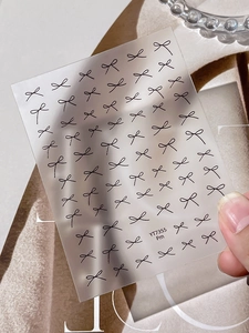 Detailed view of minimalist black line bow nail stickers on translucent film YT7355