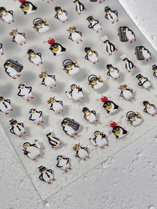 Détail d'autocollants 3D pour ongles pingouins avec divers motifs de personnages