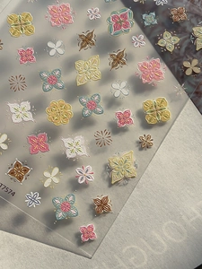 Macro detail of embossed bohemian floral nail stickers with textured 3D flower patterns