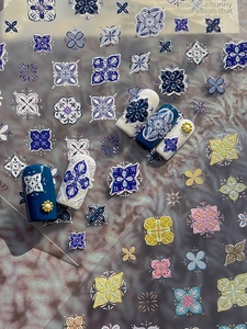 Detail of embossed bohemian nail stickers with blue porcelain patterns and 3D floral textures