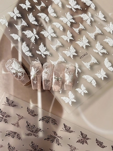 Detail of 3D embossed butterfly nail stickers with white lace texture and 3D relief effects
