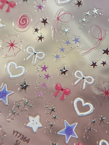 Vue macro de stickers d'ongles 3D étoile argentée et nœud rose avec éclat laser