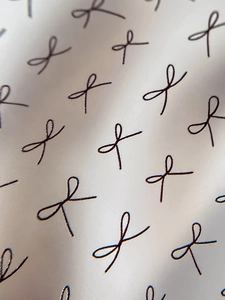 Macro view of minimalist champagne gold nail stickers with black bow patterns