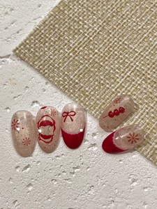 Macro view of Christmas nail tips with red snowflakes and sparkling gold bow designs