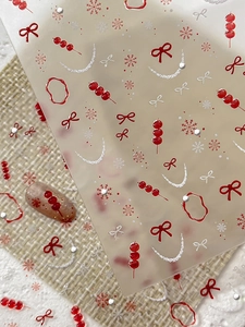 Close-up of festive nail stickers featuring red bows, snowflakes, and candied haws patterns