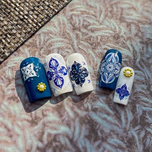Blue and white bohemian press-on nails with 3D gold accents and floral mandala patterns