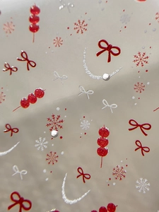 Detail of New Year nail art stickers featuring red bows, tanghulu, and silver snowflakes