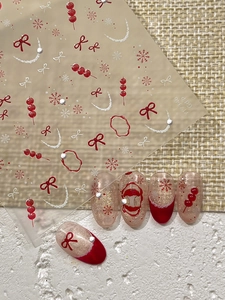 Detail of winter nail stickers featuring red bows, snowflakes and sugar gourds