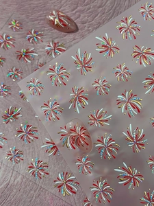 Detail of glitter firework nail stickers in gold and red for festive manicure art
