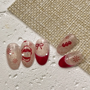 Red and nude Christmas nail patches with snowflake and bow designs on a flat background