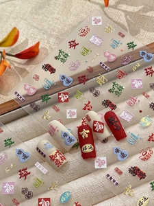 Detail of 3D embossed Chinese New Year nail art stickers with gold characters on white tips