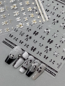 Macro detail of 3D embossed silver bow nail stickers with heart and letter patterns