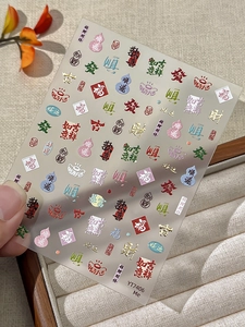 Close-up of gold-embossed New Year nail art stickers featuring traditional Chinese characters