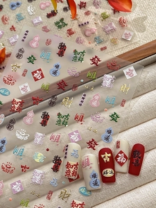 Macro detail of 3D embossed Chinese New Year nail art stickers with gold foil characters
