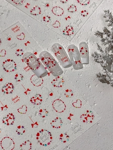 Détail d'autocollants 3D pour ongles avec cœurs rouges, strass et nœuds festifs