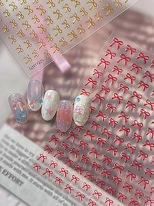 Detailed 3D red and gold bow nail art stickers with relief texture for manicure