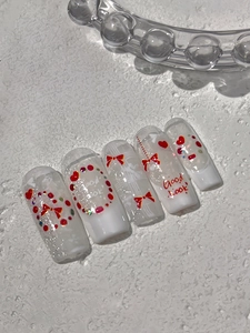 Détails de faux ongles faits main avec nœuds rouges, cœurs et texte Good Look