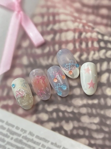 Close-up of pink and blue jelly press-on nails with 3D bows and pearl details