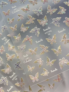 Macro detail of 3D holographic butterfly nail stickers with colorful shell finish