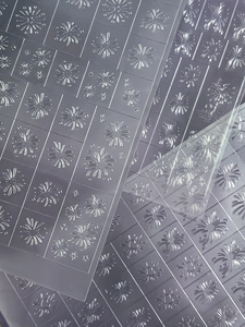 Macro shot of transparent nail art stickers with silver fireworks and heart patterns