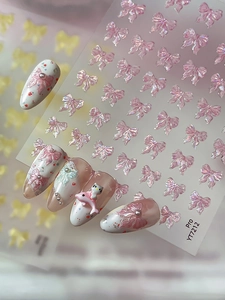 Detail view of 3D pink pearlescent bow nail stickers with embossed texture on nails