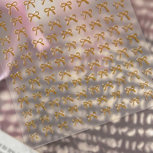 3D embossed butterfly bow nail stickers in bright orange gold with metallic finish