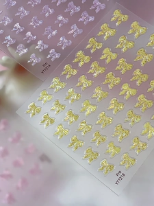 Detailed macro view of 3D aurora bow nail art stickers in purple and yellow hues