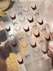 Détail macro de stickers pour ongles rouges à nœuds et pois pour manucure française DIY