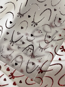 Détail macro de stickers ongles 3D en relief avec motifs de cœurs et nœuds YT7527