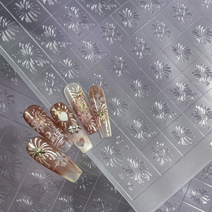 Brown and white press-on nails with 3D metal charms and glittery snowflake patterns