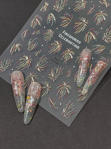 Vista macro di adesivi 3D per unghie con fuochi d'artificio rossi e oro per manicure