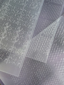 Detail of translucent nail art stencils with cow spots and checkered grid patterns