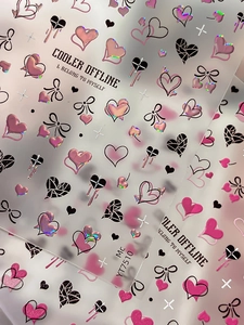 Dettaglio degli adesivi 3D olografici per nail art con motivi a cuore e fiocco rosa