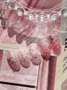 Macro detail of pink 3D embossed nail art stickers with heart and bow designs