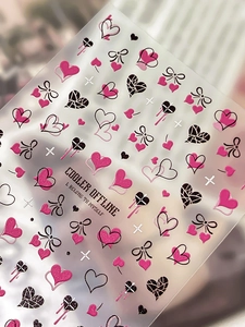 Dettaglio macro di adesivi per unghie a rilievo con cuori rosa e fiocchi neri decorativi