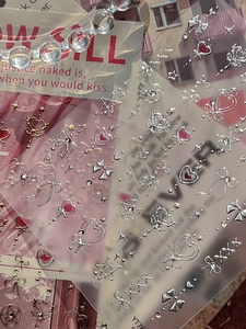 Macro shot of 3D embossed silver nail stickers with heart, star, and bow designs, model YT76