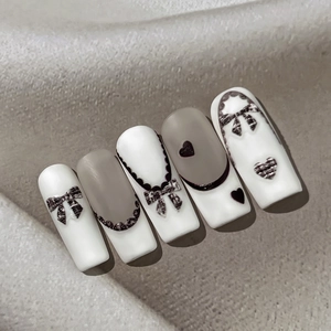 Faux ongles pied-de-poule avec nœud et dentelle, motifs de cœur sur fond cuir texturé