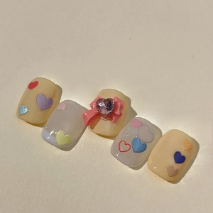 Coffret de 5 faux ongles faits main crème avec motifs cœurs colorés et nœuds en 3D
