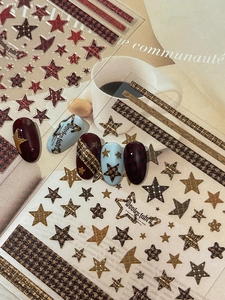 Detail of embossed houndstooth and star nail art stickers in retro burgundy and blue colors