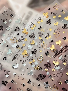 Dettaglio macro di adesivi per unghie a cuore e fiocco con texture metallica oro e argento