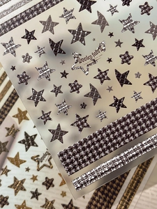 Detailed macro view of 3D embossed star nail stickers with houndstooth and woolen textures