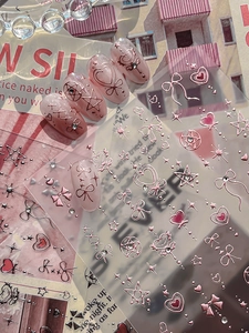 Detail of 3D embossed pink heart and star nail stickers with metallic finish effects