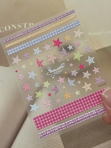 Macro shot of 3D embossed nail stickers featuring pastel stars and grid textures