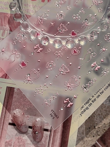 Macro detail of 3D embossed pink metallic nail art stickers with bows and hearts