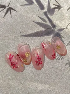 Detailed view of pink gradient press-on nails with koi fish patterns and gold accents