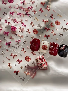 Detail of red plaid nail stickers featuring horse, apple, and bow patterns for manicures