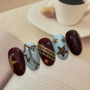 Elegant long oval press-on nails featuring houndstooth pattern and gold star accents