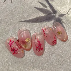 Press-on nails featuring red koi fish and gold snowflakes on pink gradient base