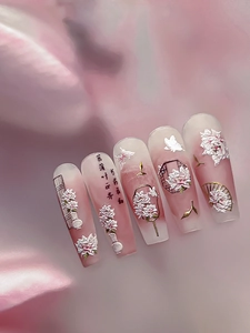 Détail de fleurs 3D et d'éventails sur ongles à presser avec dégradé de rose